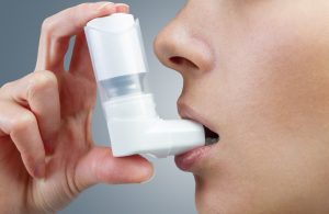 child taking asthma inhaler