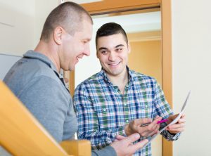 landlord handing a tenant a contract to sign