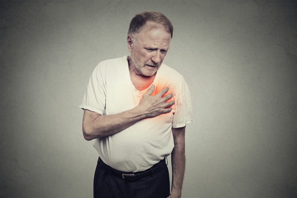 A senior man clenching his chest due to pain