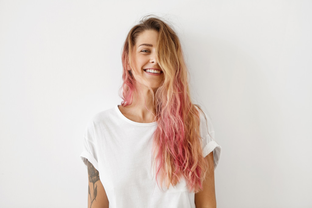 female with blonde and pink hair smiling
