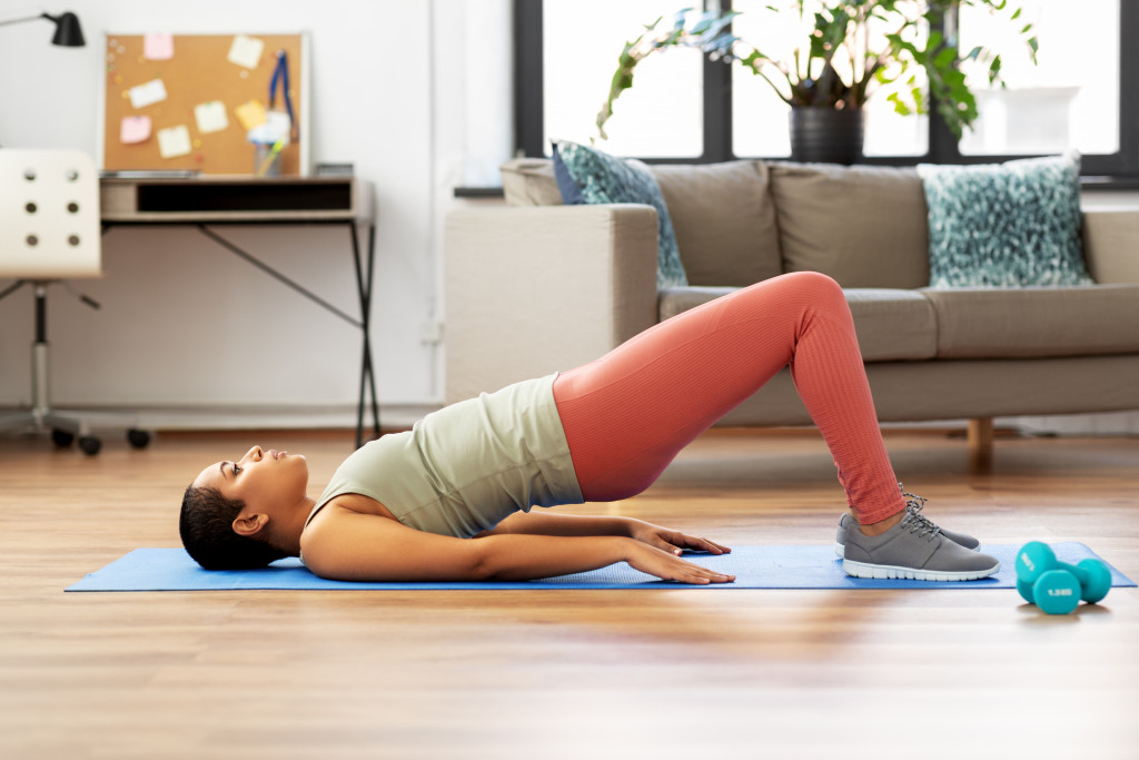 woman doing hip or glute bridges in yoga mat