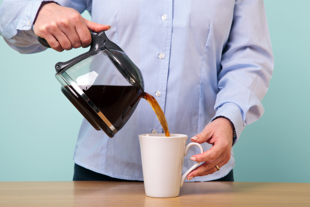 A woman pouring coffee into a cup