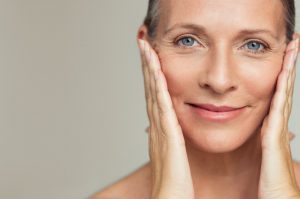 Close-up of a middle-aged woman holding her face