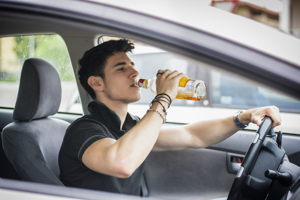 An addicted man drinking while driving