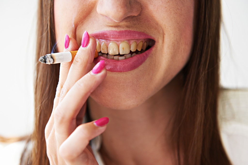 Woman smoking with yellow teeth