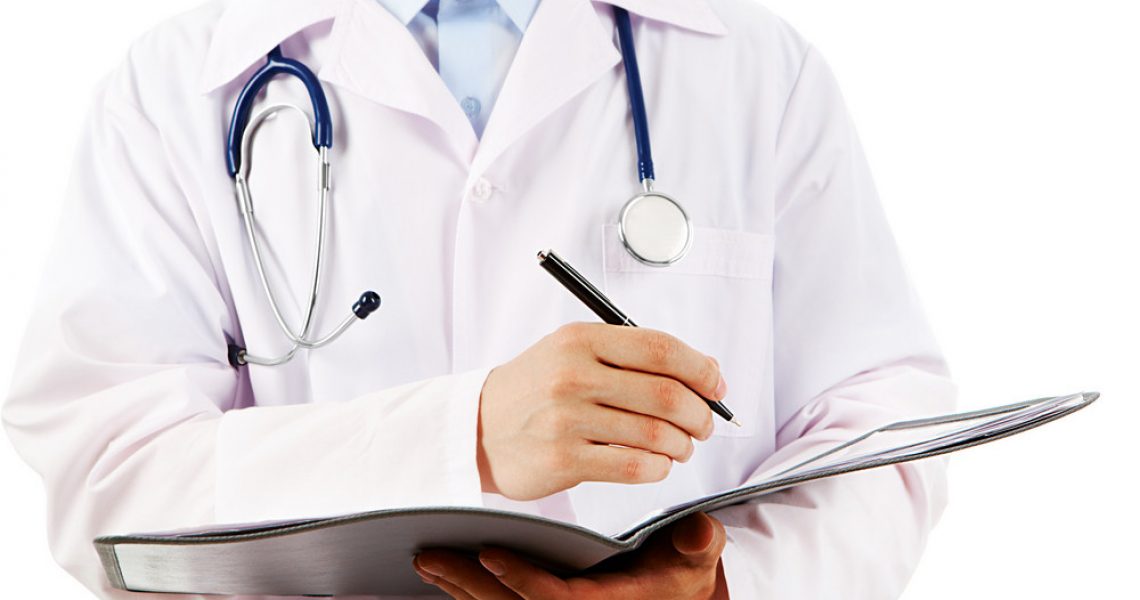 Close-up of physician writing down prescription in medical card