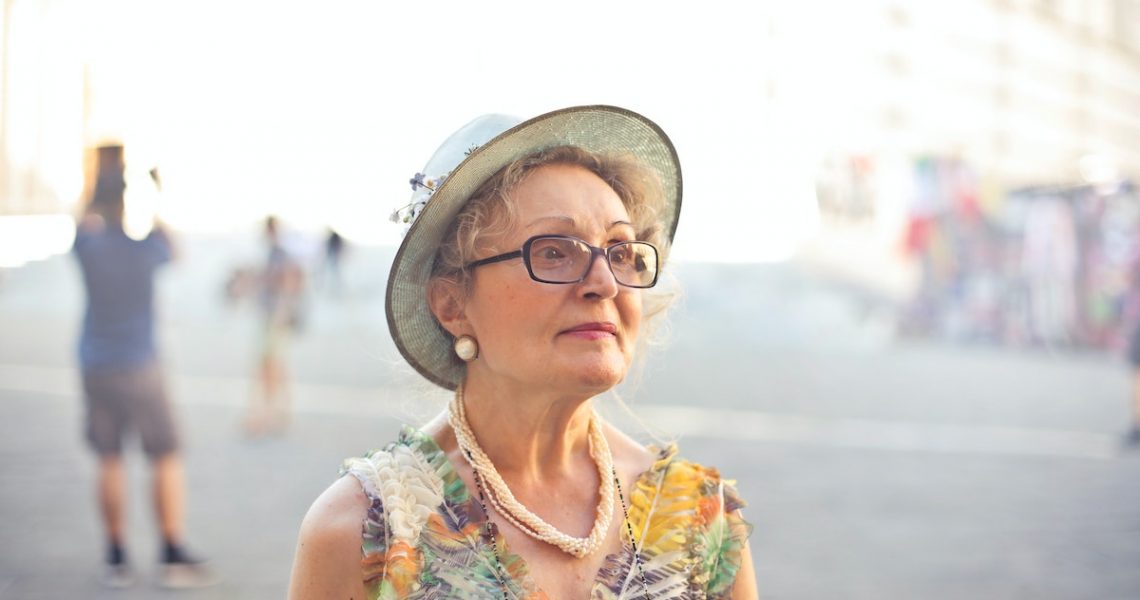 Depth of Field Photography of Woman in Pastel Color Sleeveless Shirt and White Sunhat
